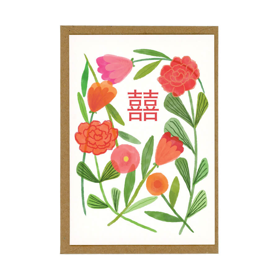 A eco friendly card on top of a brown envelope featuring a design of red flowers and a double happiness Chinese character