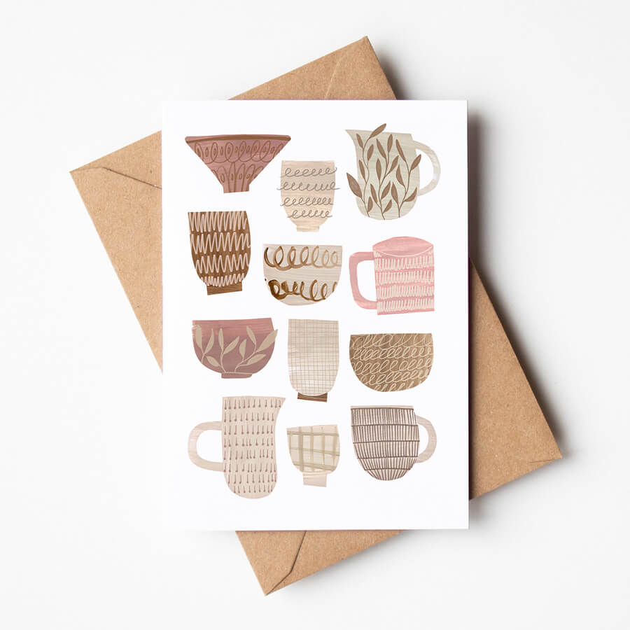 A greeting card featuring a digital reproduction of collage cups, bowls and jugs. Card is resting on a brown envelope