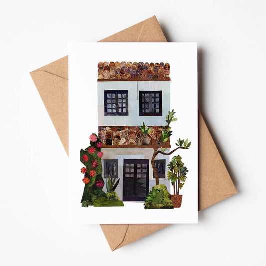 A greeting card displayed on a brown envelope featuring a stylised traditional Malaysian shophouse facade