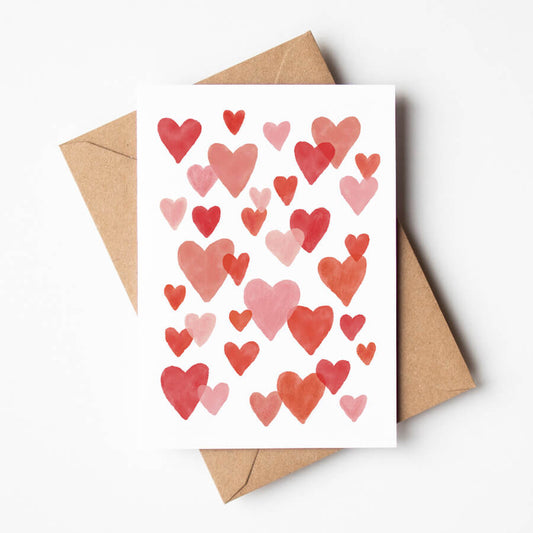 An illustrated card featuring lots of pink and red love hearts on top a brown paper envelope