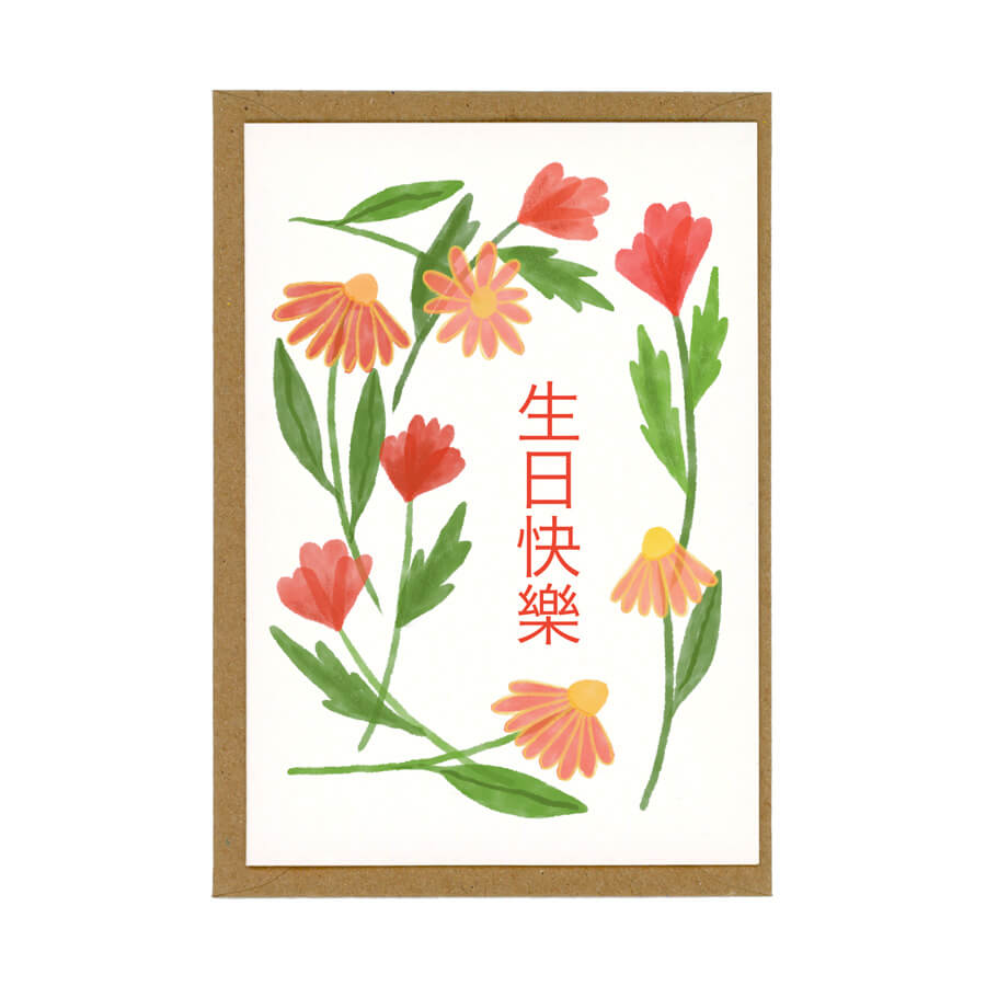a red floral card with the words 生日快樂. Card displayed on brown envelope and made with eco friendly materials