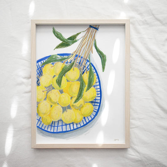 A framed illustrated art print of fresh longan fruit in a blue plastic basket