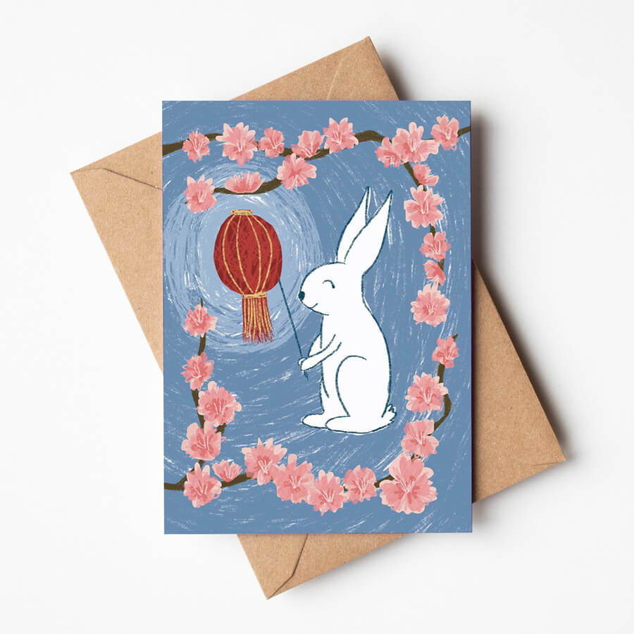 An eco friendly card to celebrate the Lunar New Year - an illustrated rabbit holding a lantern surrounded by lucky plum blossoms