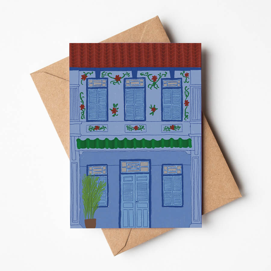 A eco friendly greeting card displayed on top of a brown envelope featuring a traditional malaysian heritage shophouse